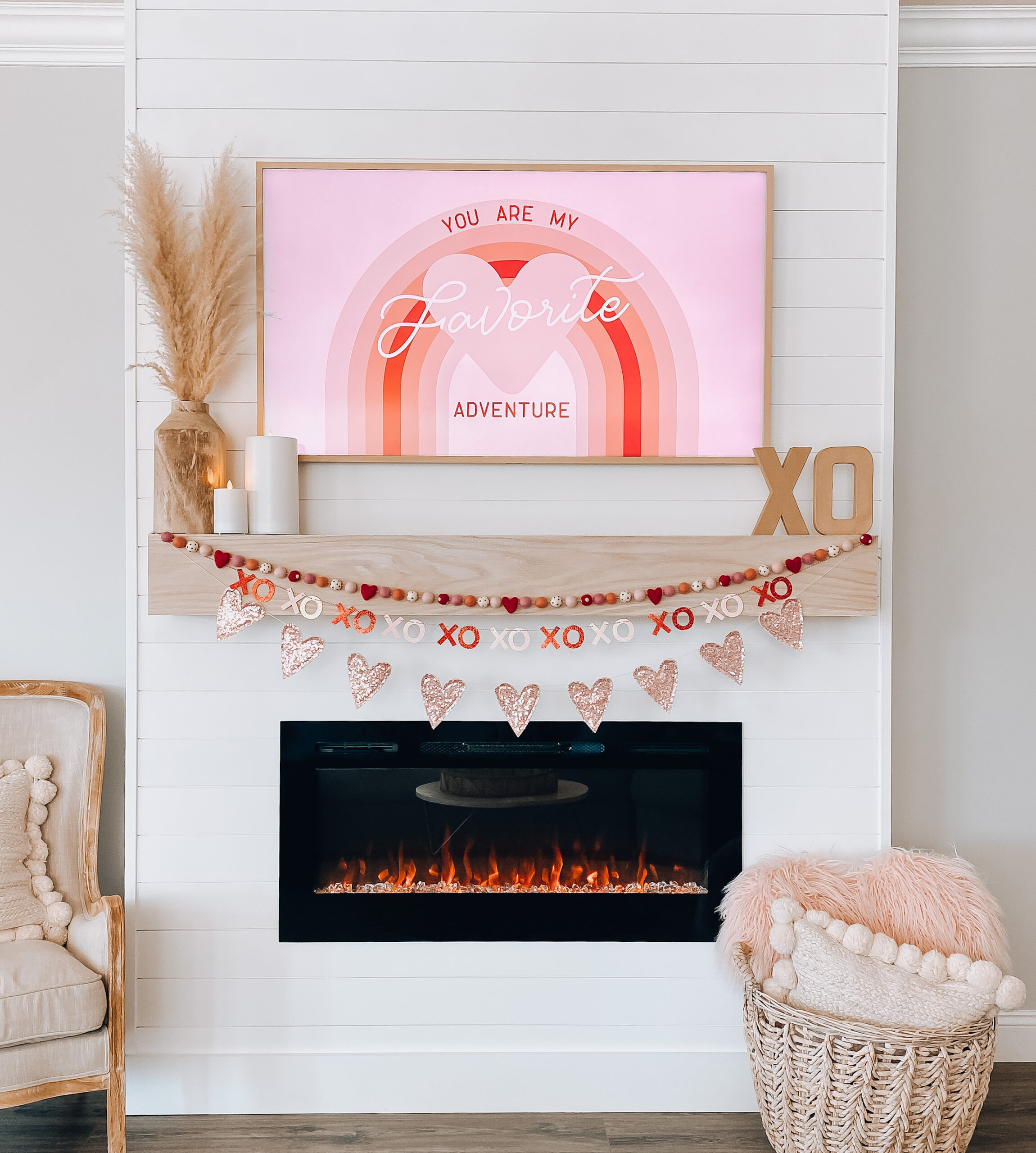 fireplace mantel with red and pink garlands with rainbow image on tv You're my Favorite Adventure