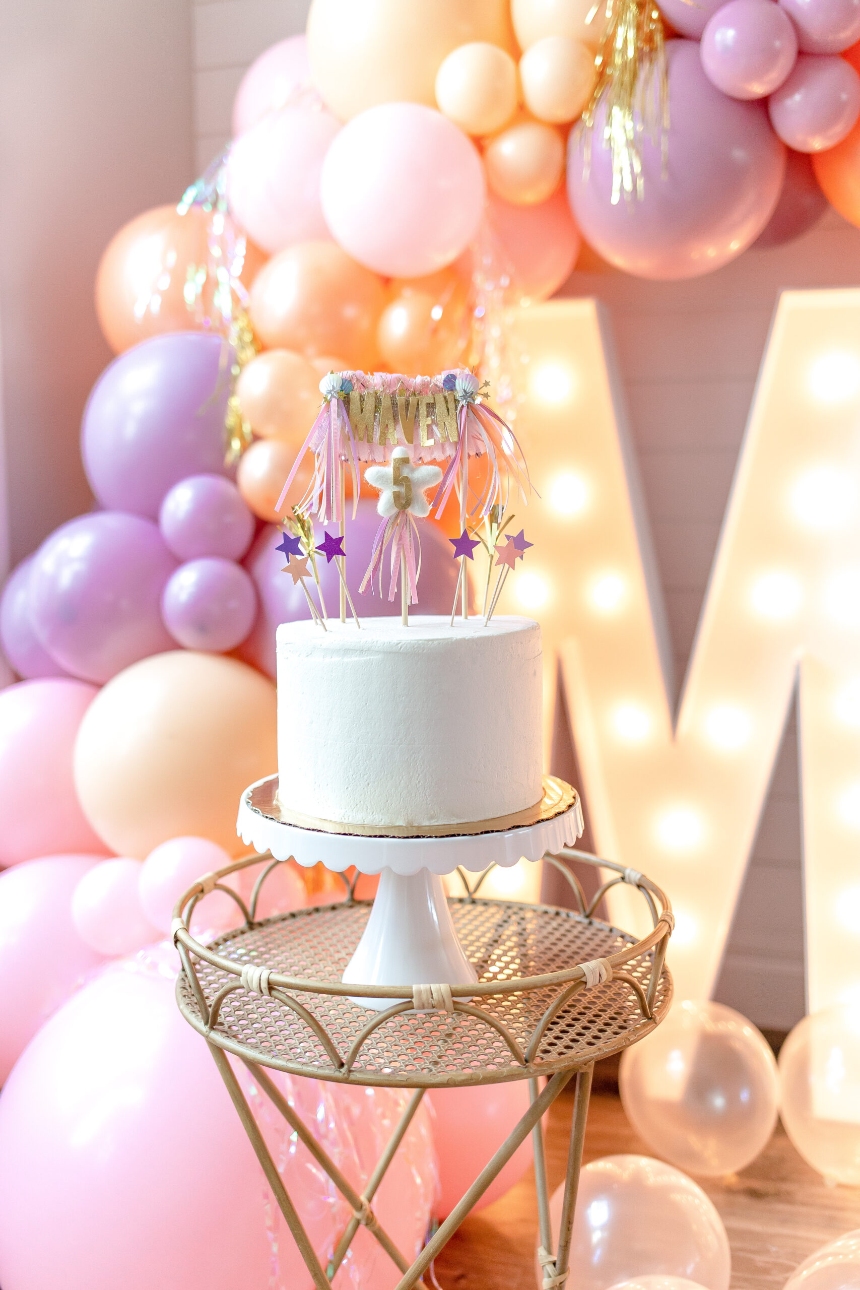 Maven cake topper with purple and pink fringe for 5th birthday party